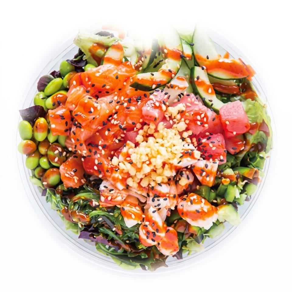 Overhead view of a colorful poke bowl with salmon, tuna, shrimp, edamame, and cucumber.